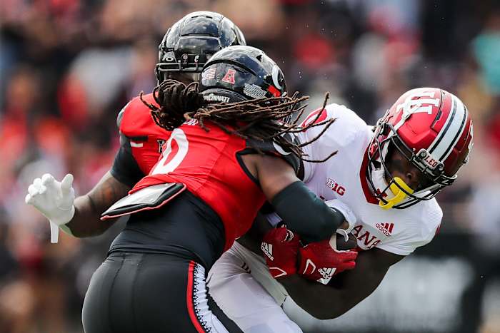 Sep 24, 2022; Cincinnati, Ohio, USA; Cincinnati Bearcats cornerback Arquon Bush (9) brings down Indiana Hoosiers wide receiver Andison Coby (10) in the first half at Nippert Stadium. Mandatory Credit: Katie Stratman-USA TODAY Sports
